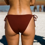 Person wearing a red bikini on a beach with ocean and sand in the background
